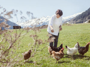 Frau füttert die Hennen mit Brot